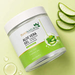 Jar of aloe vera gel with aloe vera leaves on a light green background
