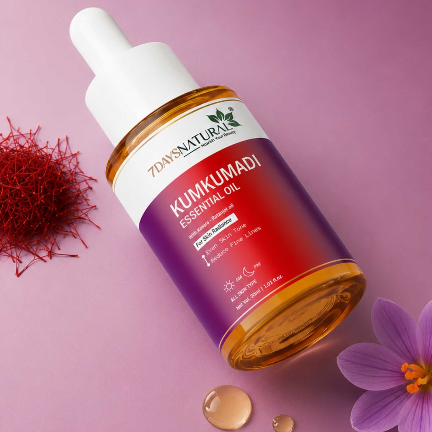 Bottle of 7Days Natural Kumkumadi Essential Oil on a pink background with saffron and a flower.