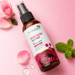 Rose Glow face toner bottle with pink roses and mint leaves on a pink background